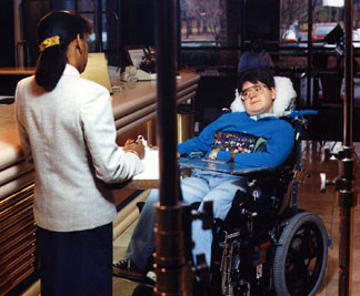 man in wheelchair at hotel desk