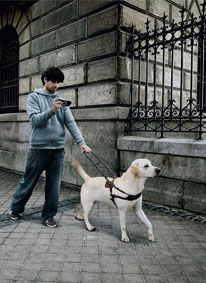 man with guide dog using a talking gps unit